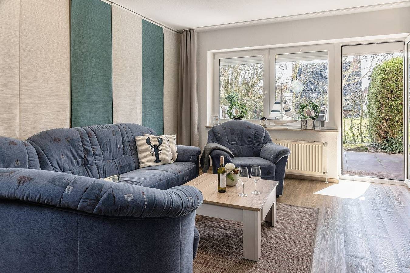 Vollends auf Bequemlichkeit aus: Die Erdgeschosswohnung mit ihren ca. 60 qm brilliert durch das komfortable Interieur und die schöne Terrasse. Ferner liegt sie direkt am Yachthafen, in dem zahlreiche Segelschiffe und Motoryachten während der Sommersa — Bild 2
